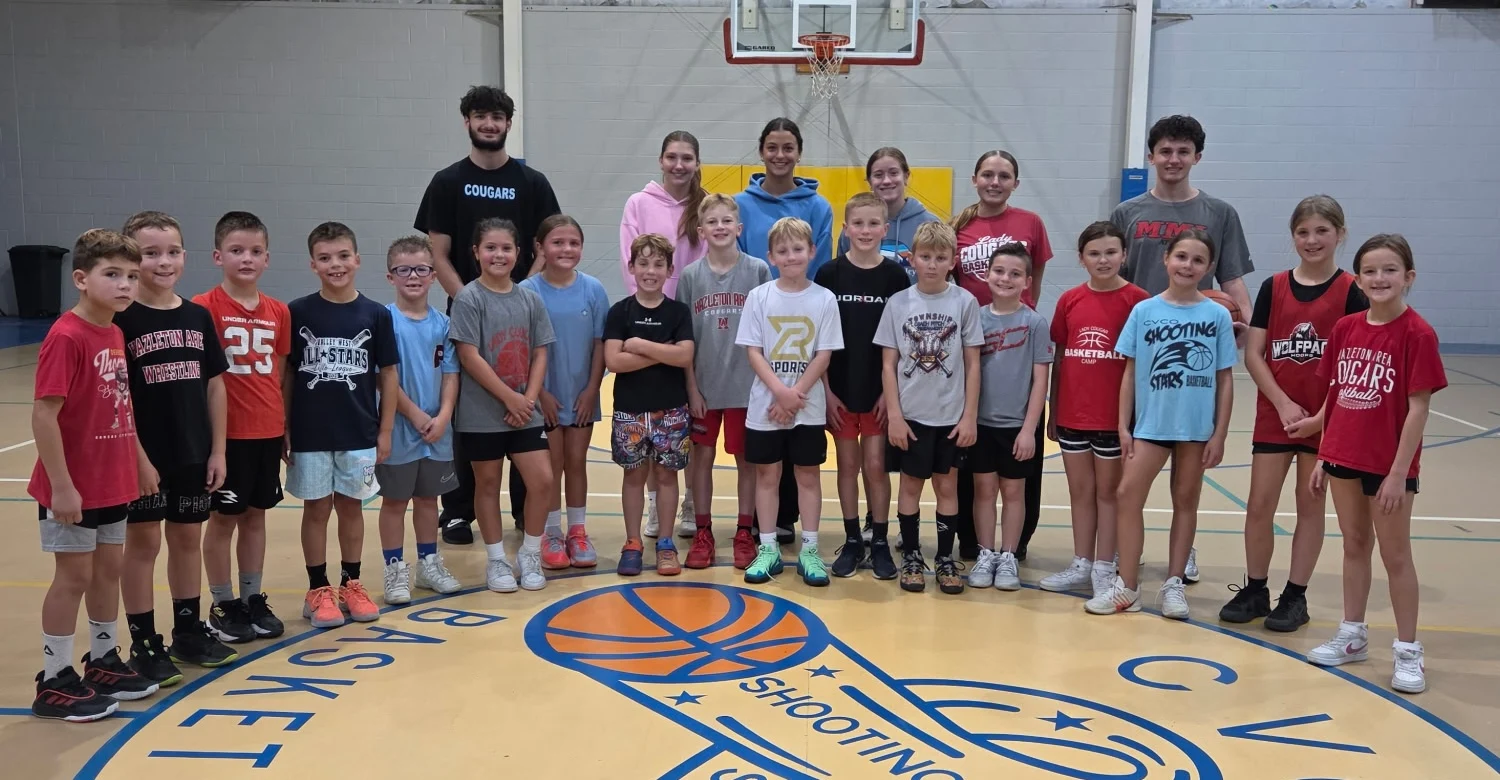 Grades 2–4 clinic players and coaches posing together at CVCO Gym